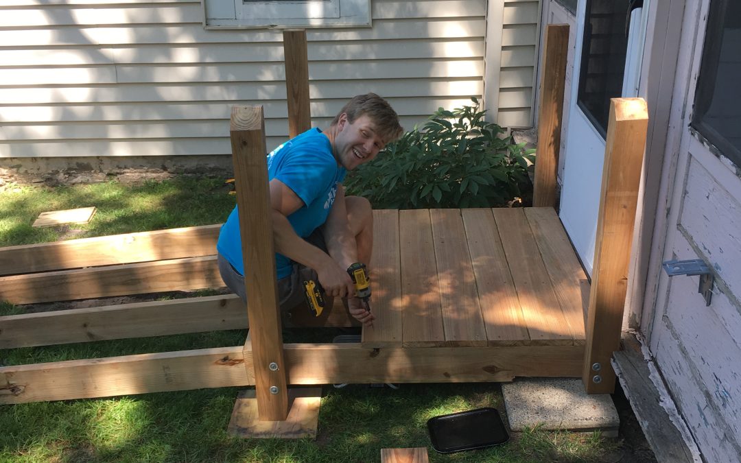 a worker installs a landing outside a home