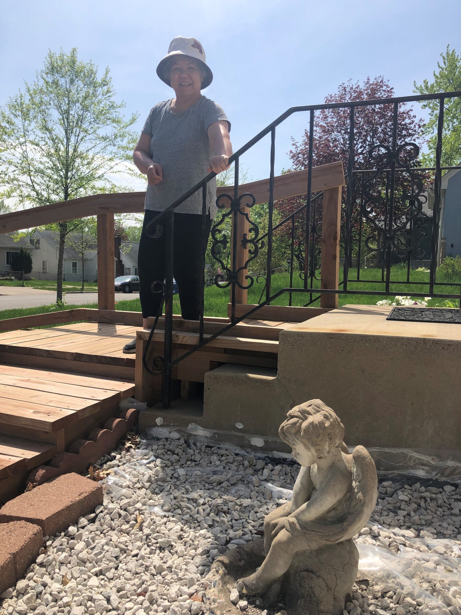 Maylee stands on the steps next to a statue of an angel